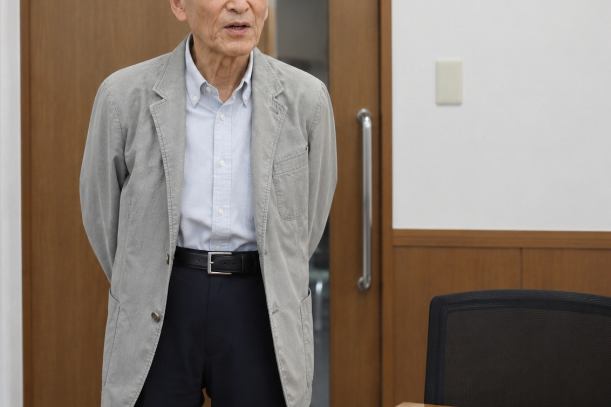 コールセンターで発信の電話をかける70代男性の手元